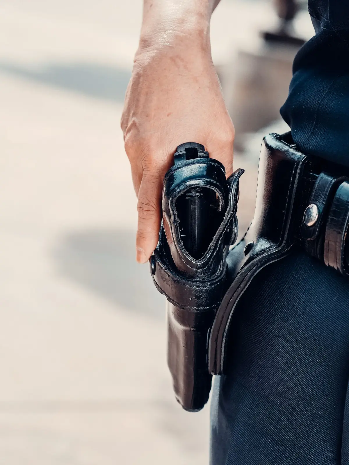 Hand resting on a holstered handgun