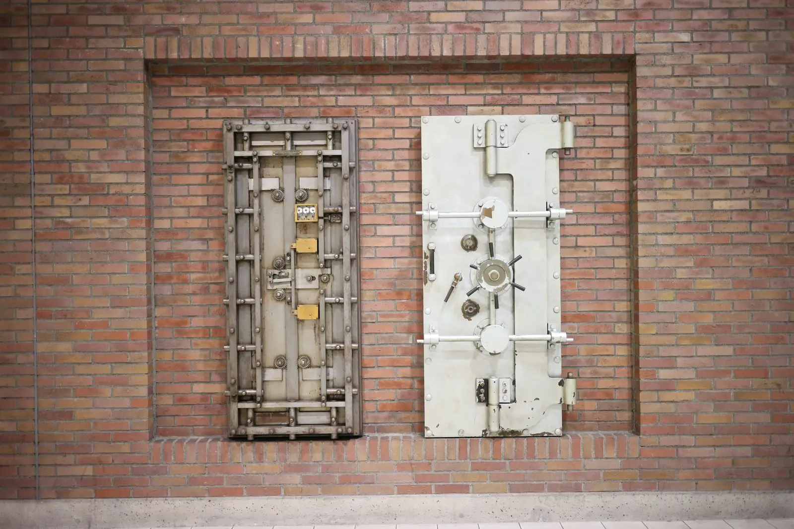 Steel vault doors against a brick wall